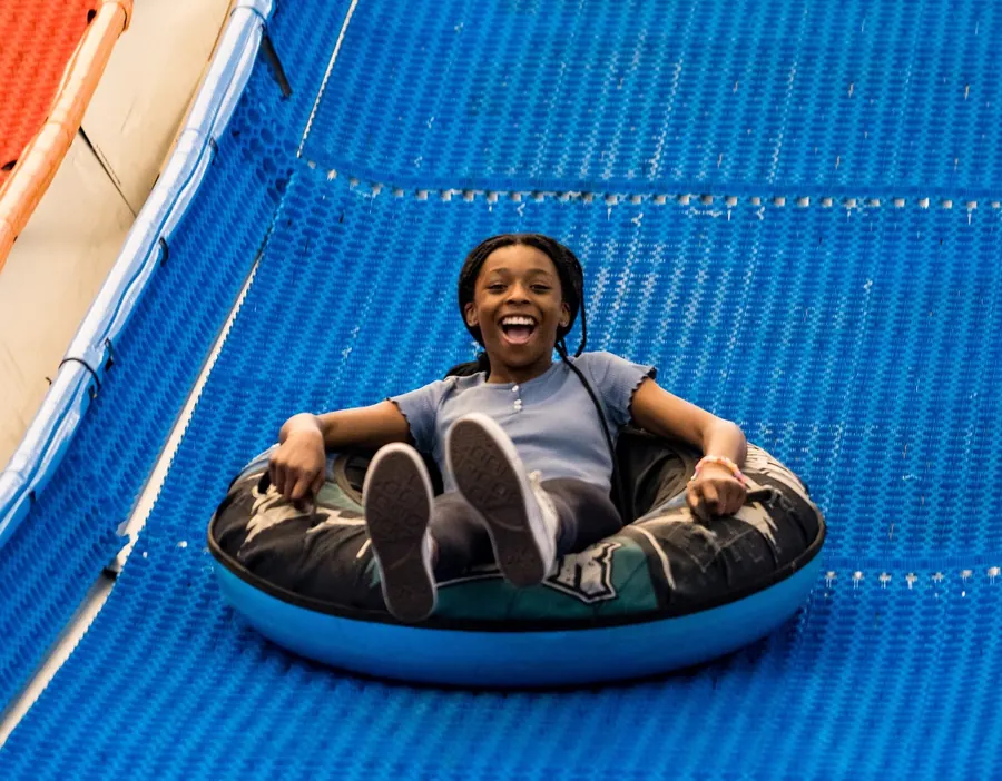 Guest riding a tube down the Tubing Slides